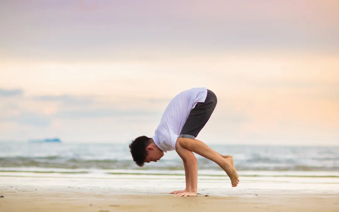 un homme qui pratique la callisthénie sur la plage