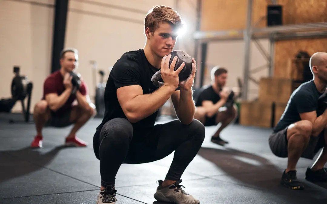 Athlète réalisant un goblet squat, kettlebell tenu devant la poitrine