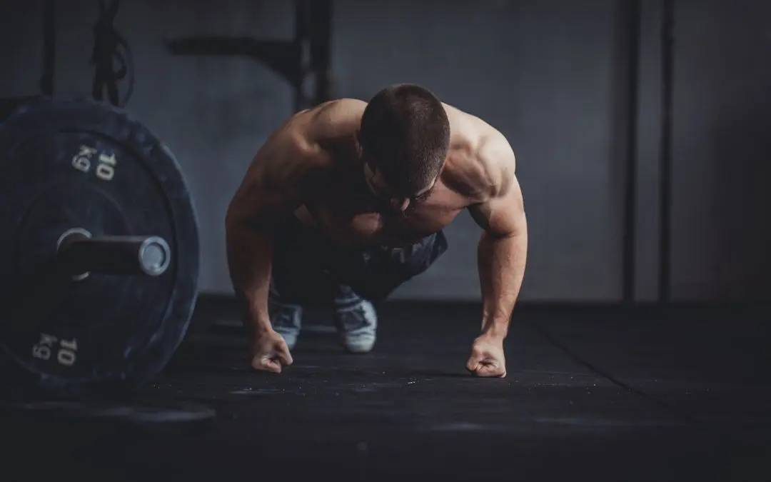 Athlète réalisant un push up (pompe) en position de gainage