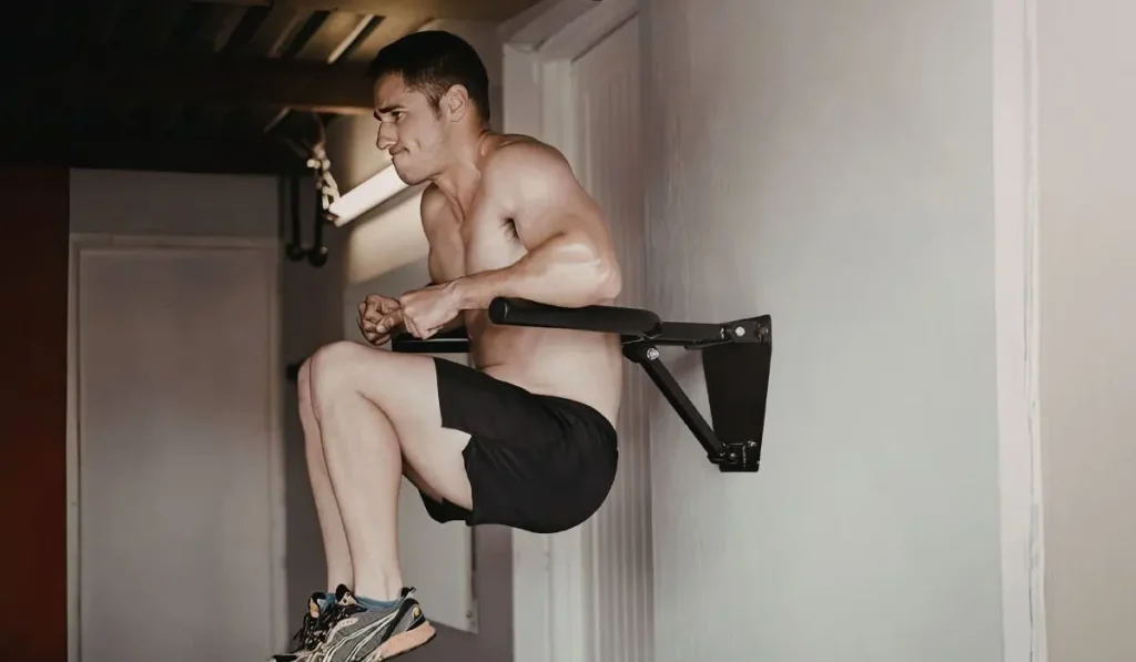 un homme qui s'entraine sur une barre de traction murale